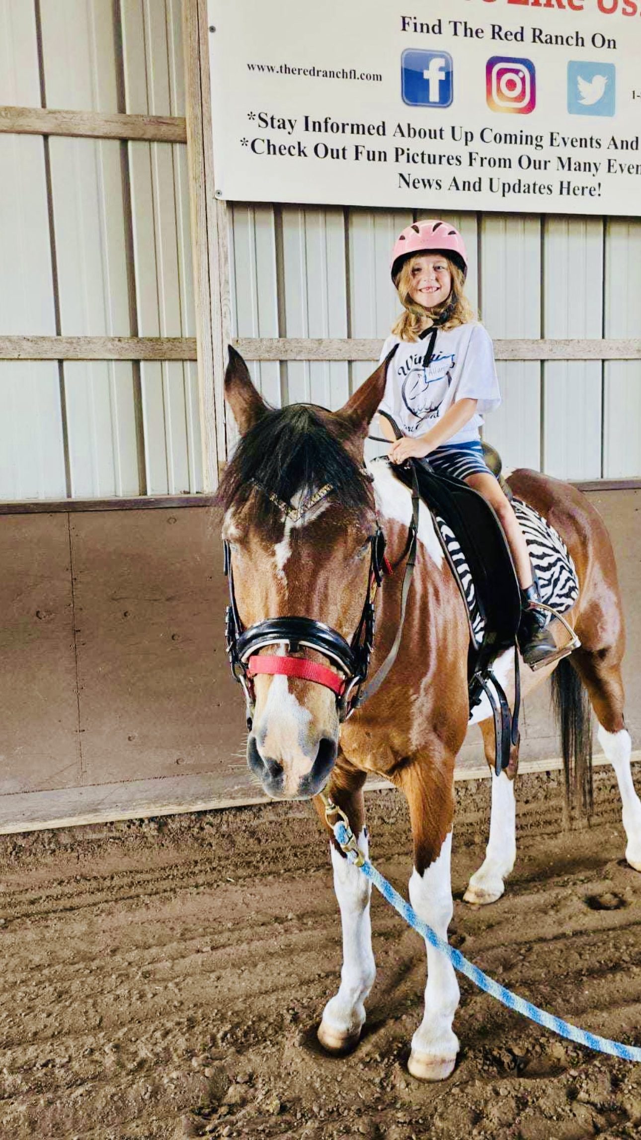Camper smiling beside a pony